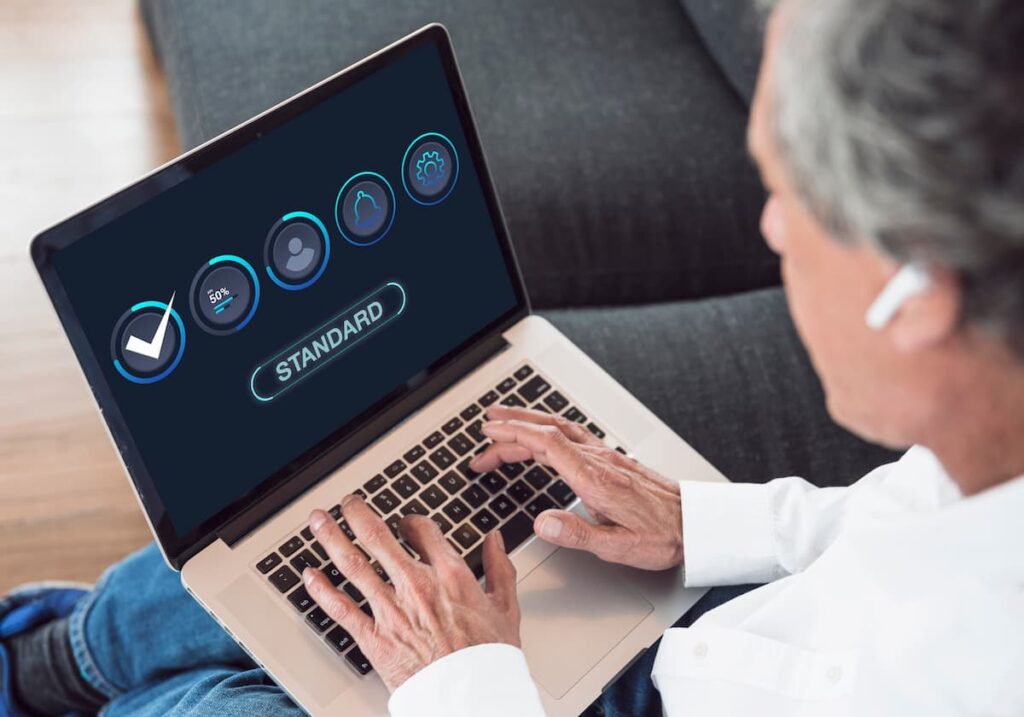 man holding computer that says standard