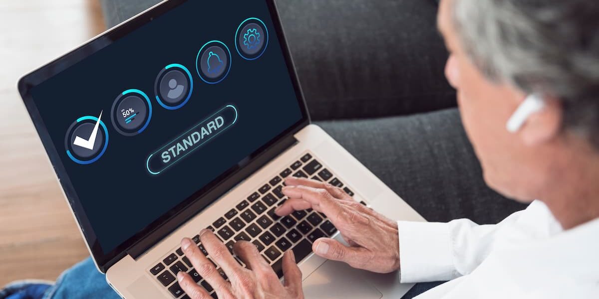man holding computer that says standard